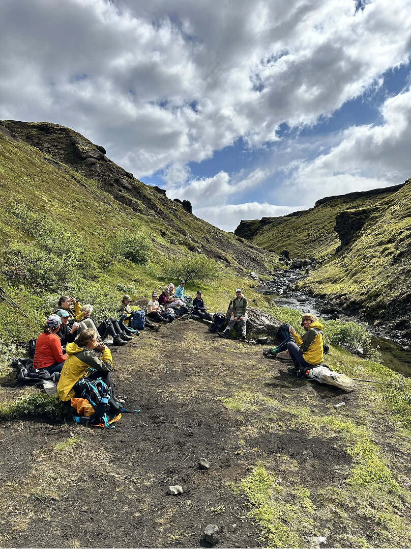 Hikers resting in a green canyon