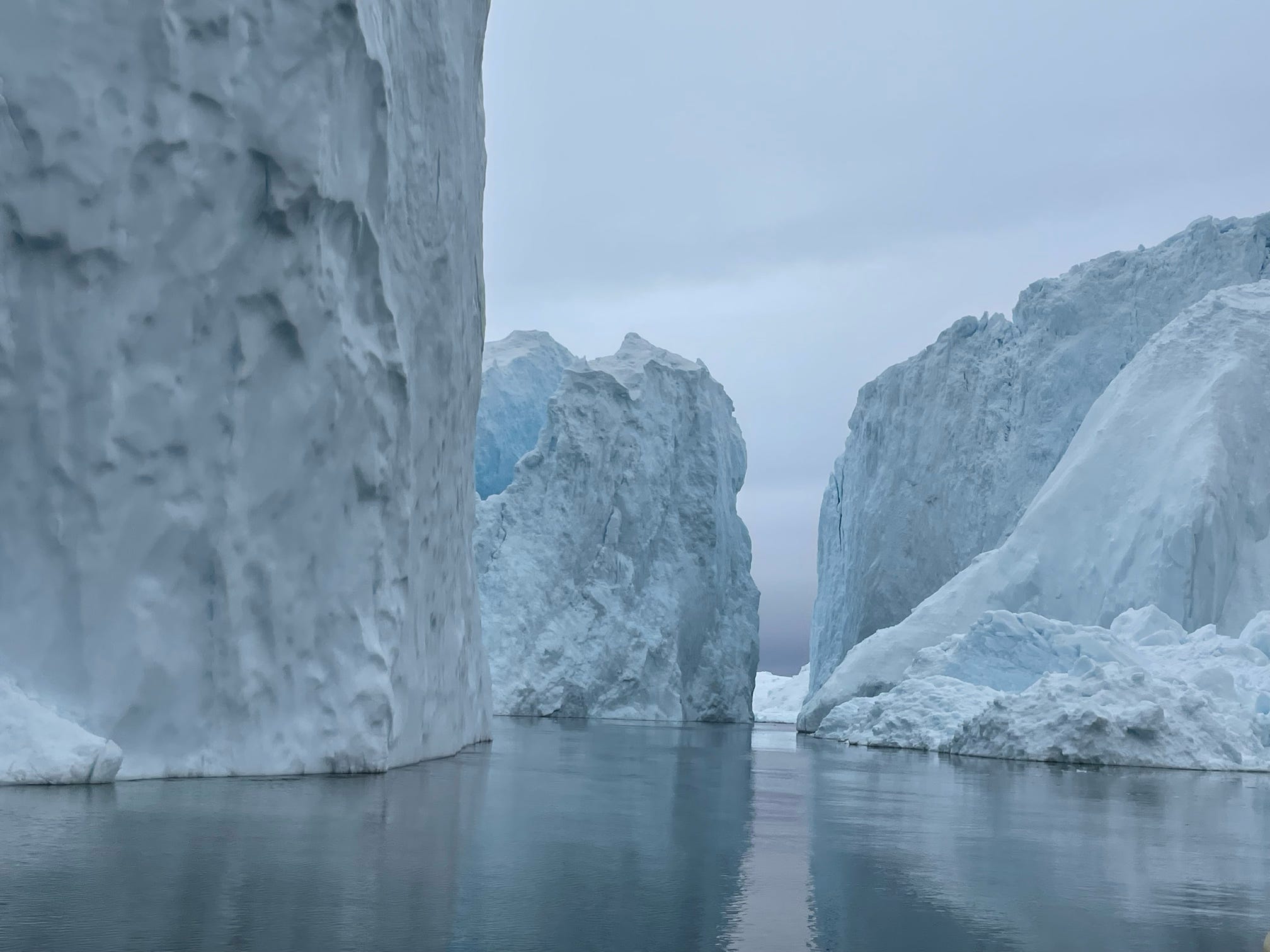 Towering icebergs reflected in calm water