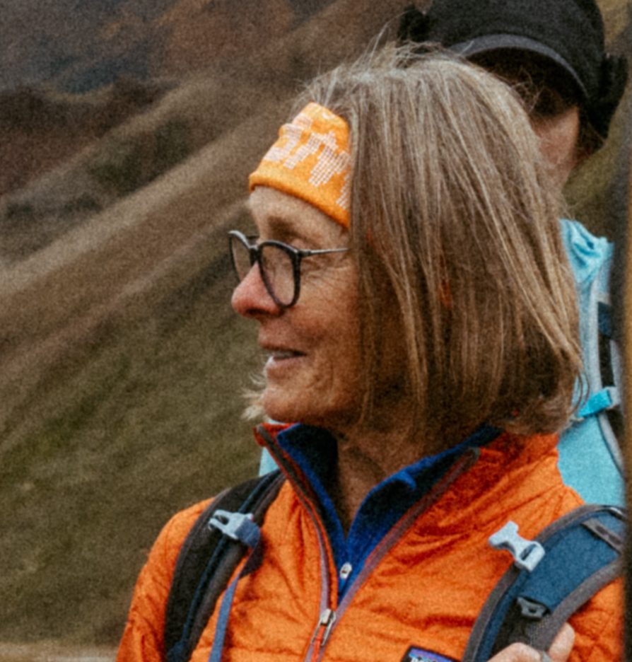 Smiling woman in glasses and an orange headband on a hike