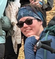Smiling woman in sunglasses and a headband on a hike