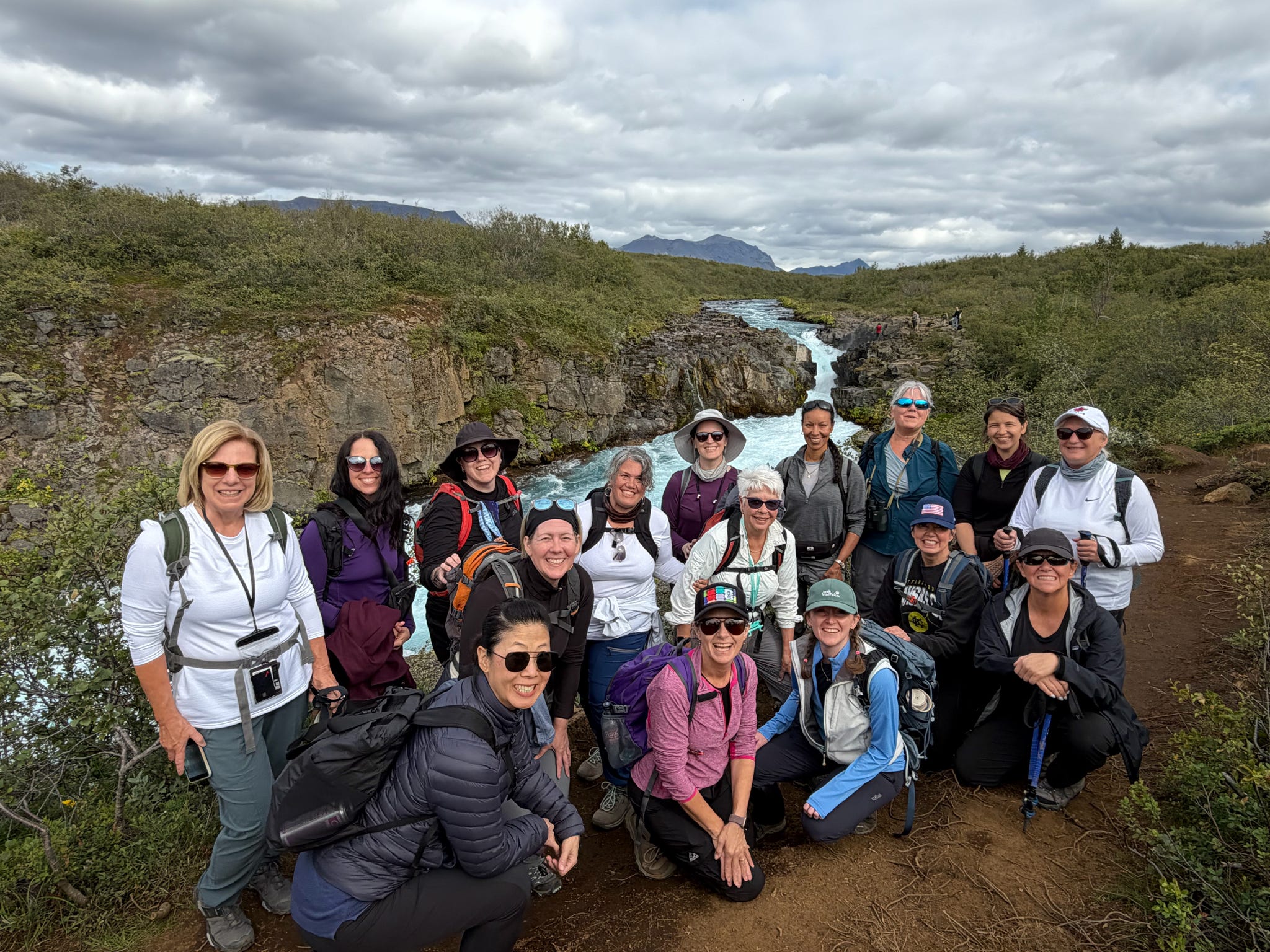 Large group of women hikers posing by a river