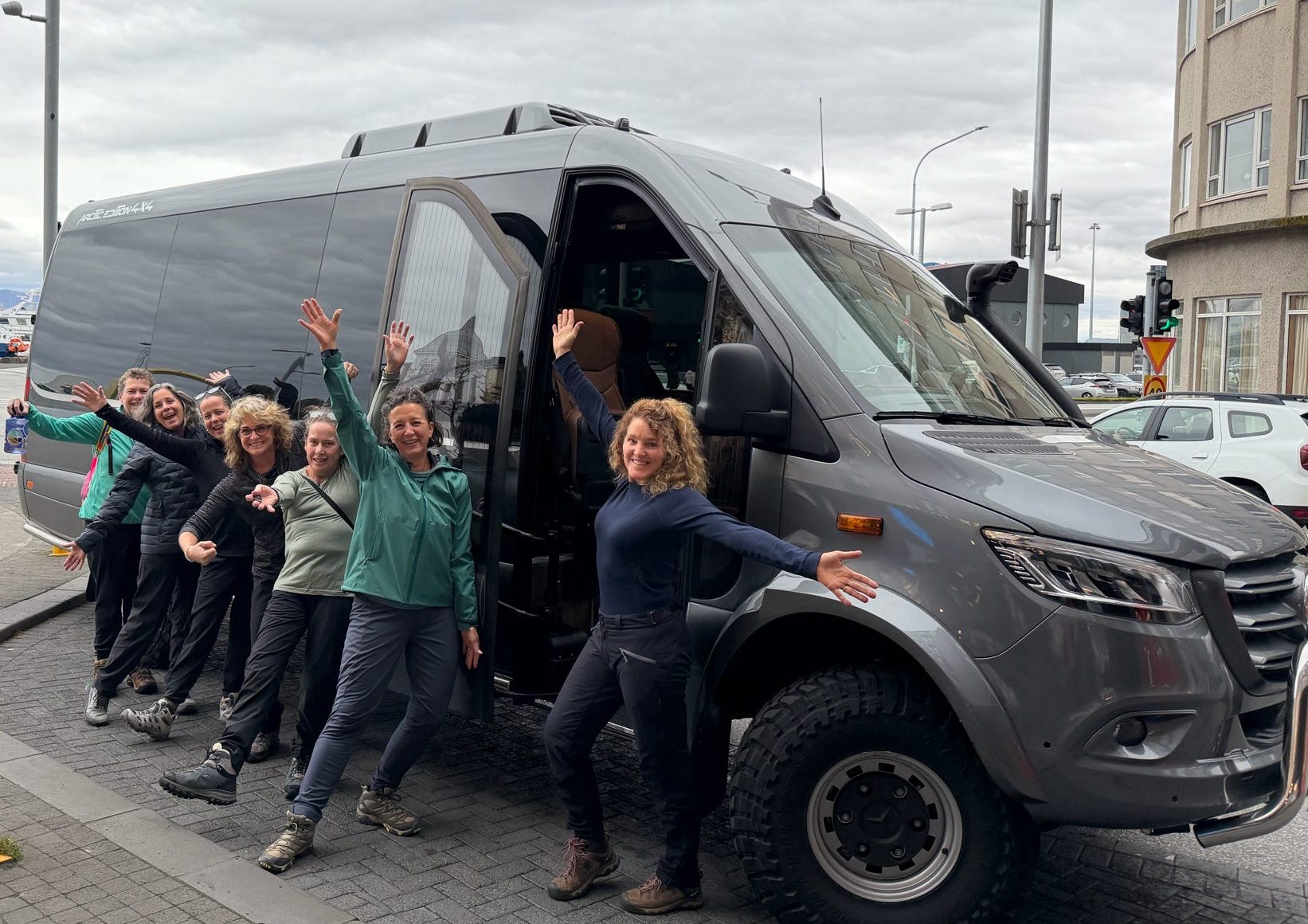 Group of women posing by a tour van