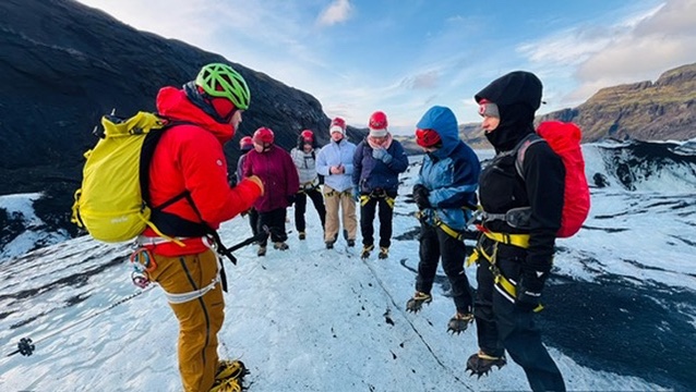 Group in helmets and crampons on a glacier