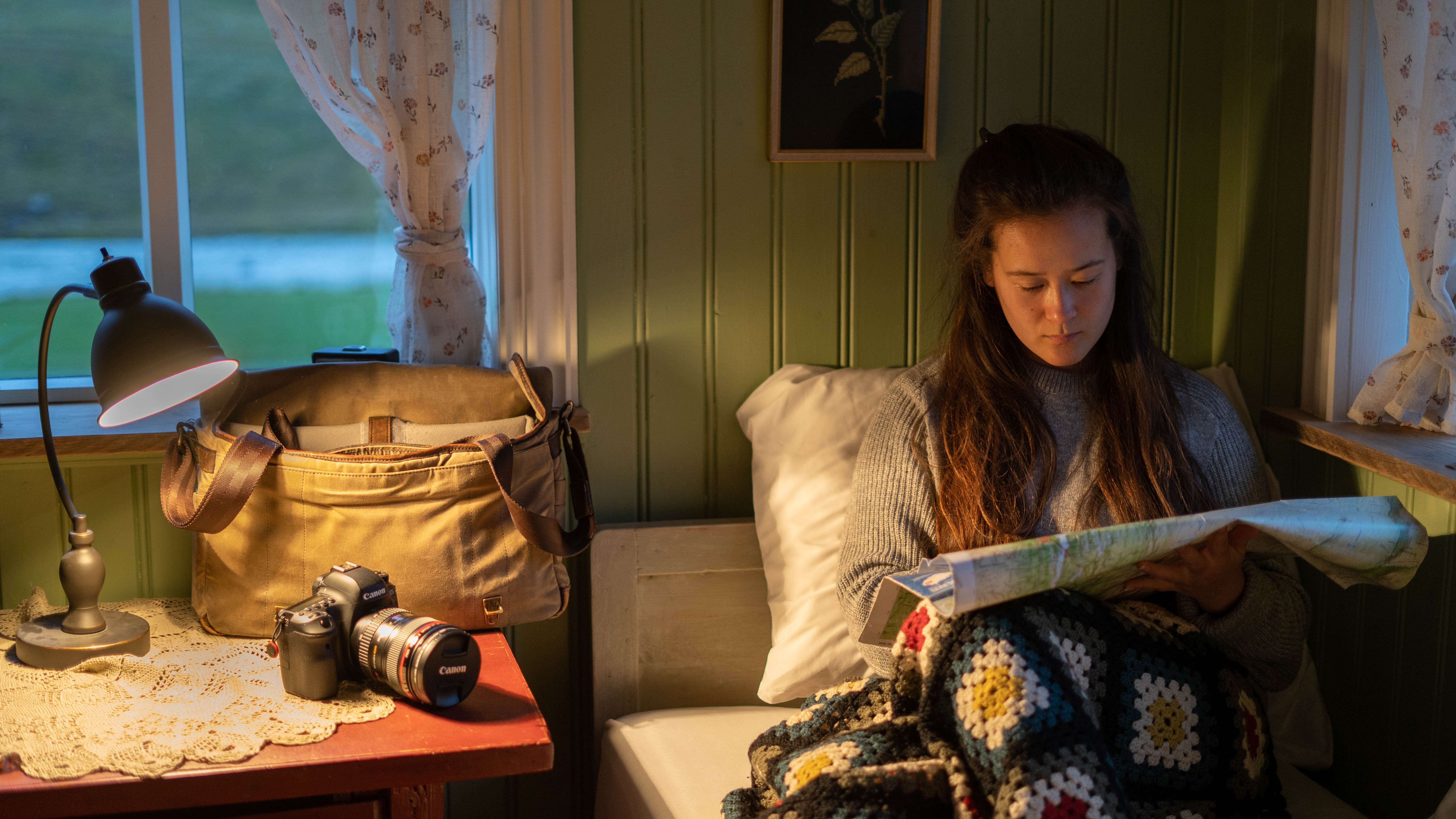 Woman reading a map at a desk in a cozy room