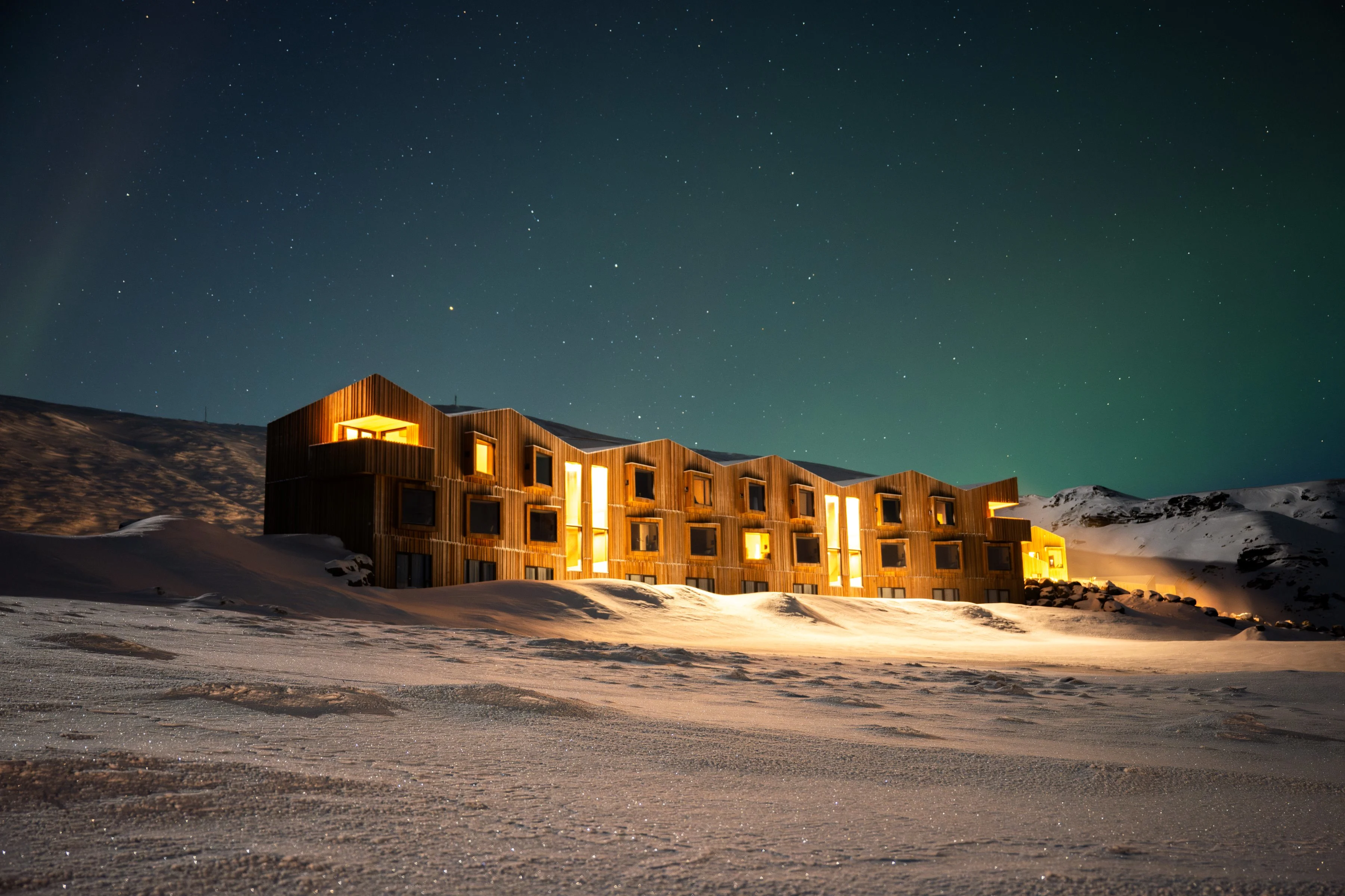 Hotel lit up at night under the northern lights