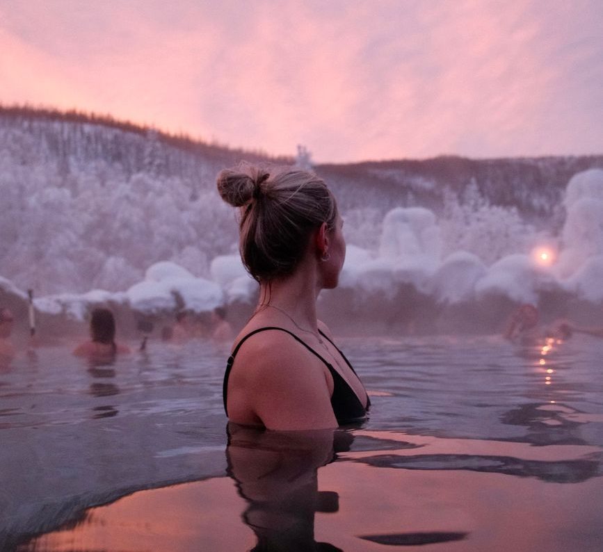 blonde woman in water in winter at dusk