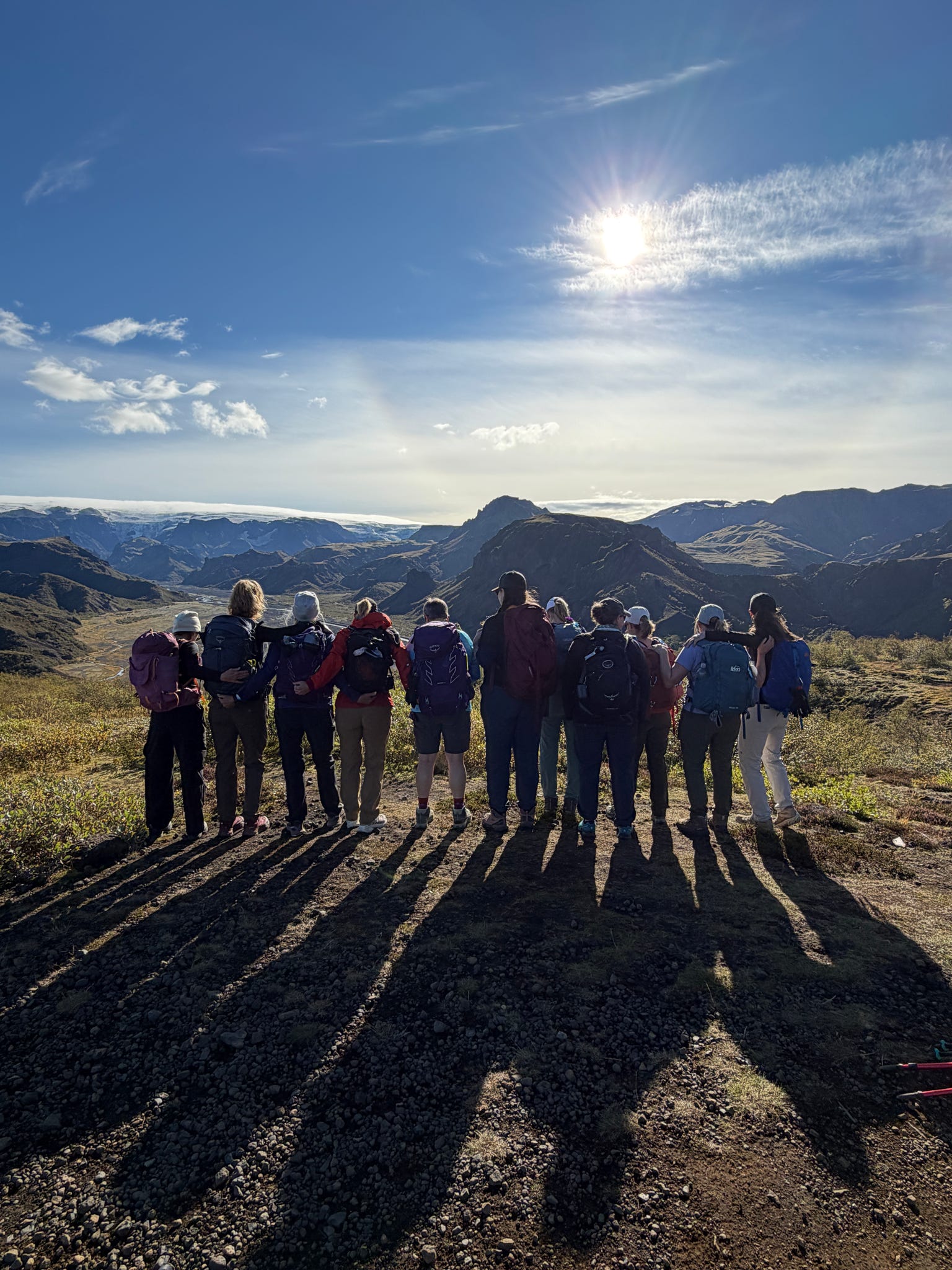 Group of hikers silhouetted on a ridge at sunset