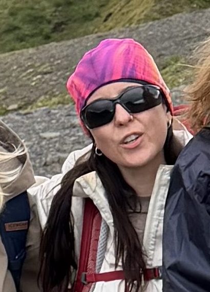 Woman in a pink hat and sunglasses taking a selfie on a hike