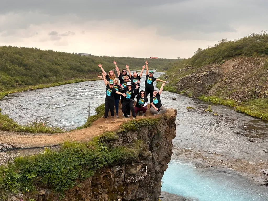 Group of women posing on a rocky ledge above a river