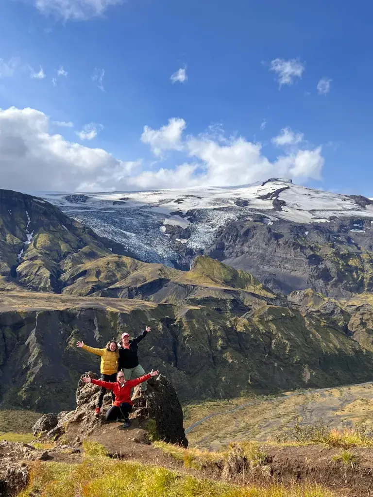Hiker posing on a rock in front of a glacier-capped mountain